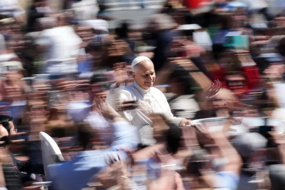 Pope Leo XIV greeting the faithful from the popemobile